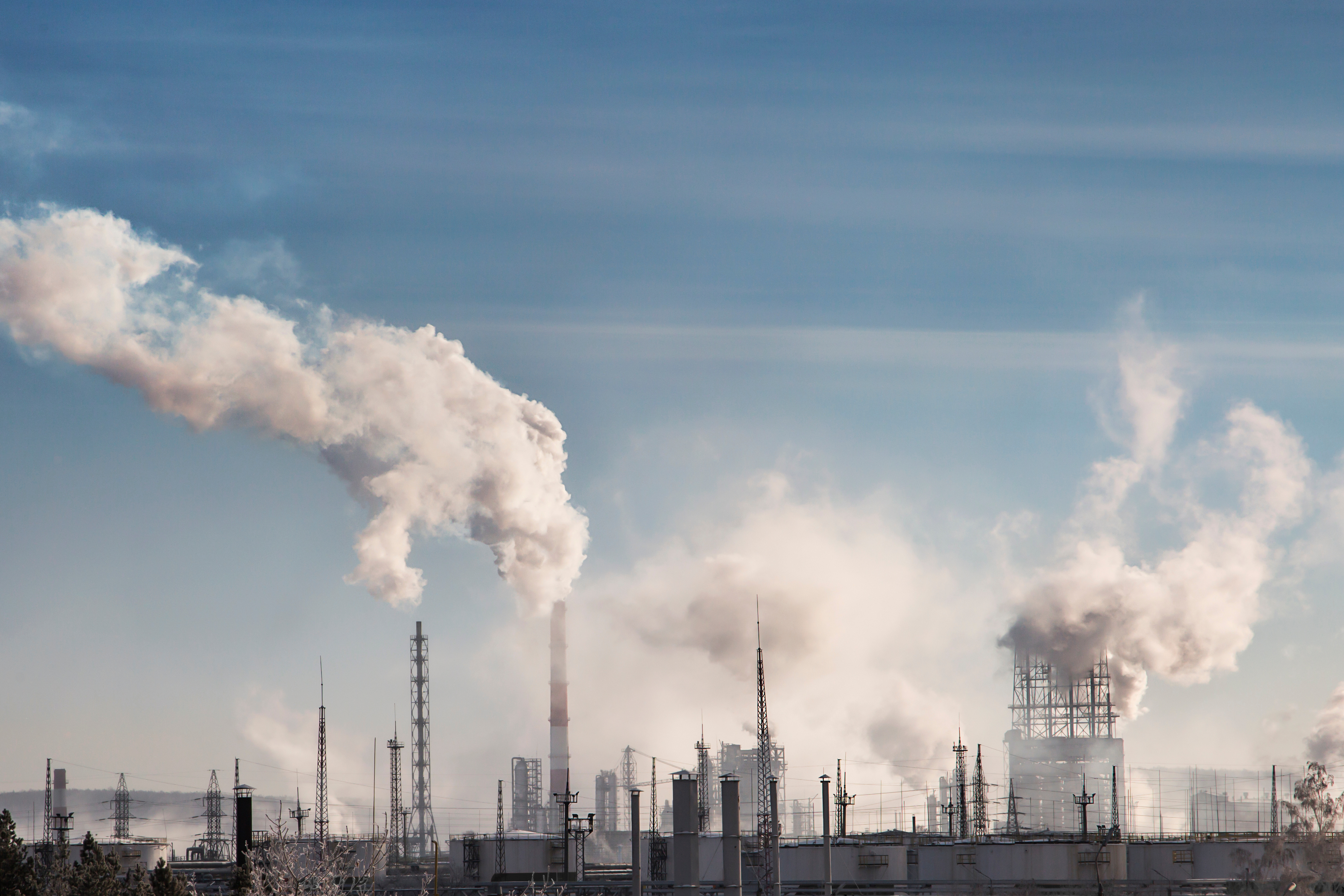 An industrial complex emits smoke and pollutants into the air.